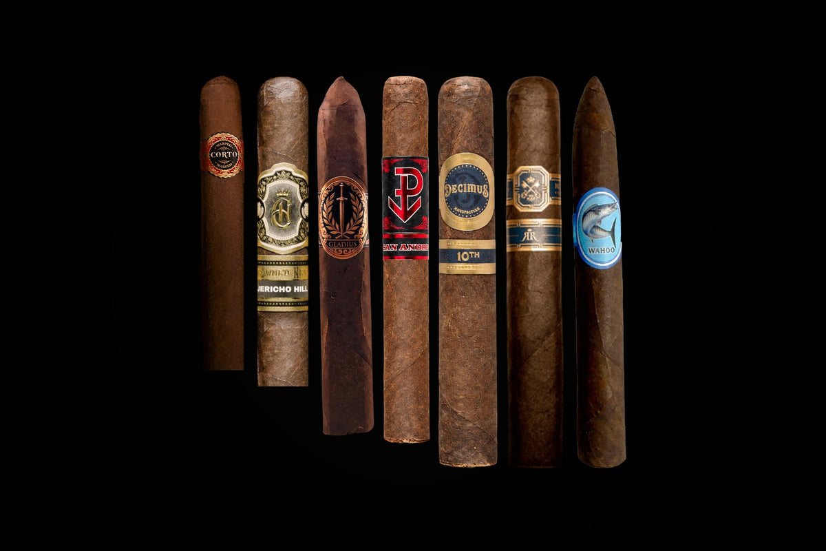 Boutique cigars from Warped, Crowned Heads, Tradecraft, Valacari, Rodriguez and Lure lined up on black