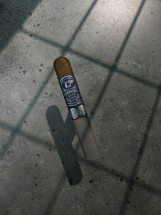 Cigar with a blue wrapper on a concrete surface