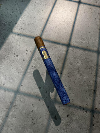 Cigar with a blue wrapper on a tiled floor