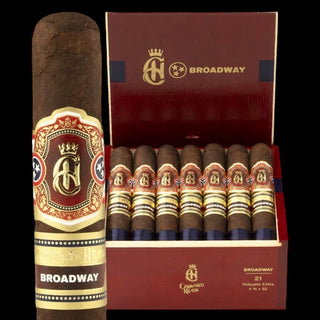 A single premium cigar shown upright beside an open matching box containing 21 cigars. The cigars have dark brown wrappers with gold and red bands, and the packaging is a deep burgundy red with gold lettering and logos.