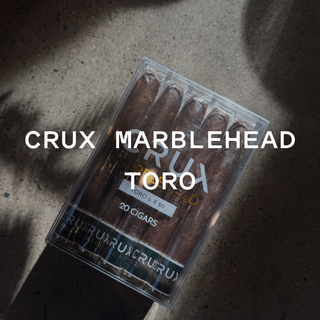 Pack of Crux Marblehead Toro cigars on a textured surface