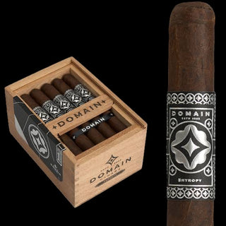 Domain Entropy cigars shown in a light wood box alongside a single upright cigar with a silver and black Domain label, on a black background.