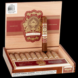 A box of El Tan de Oro cigars, featuring an open wooden presentation box with a single upright cigar and several cigars arranged inside. The box lid displays a large red and gold crest with the brand name 'El Tan de Oro' and 'Redemption' and 'Little Havana' printed on the sides.