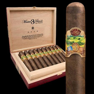An open wooden cigar box containing several cigars with green and gold bands, shown beside a single large cigar with a colorful label on a black background. The box lid is printed with 'Misterio 3 Blends' and 'Luis Maestria'.