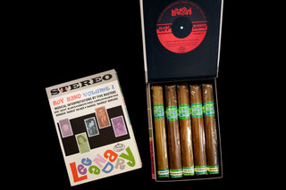 Packaged cigars with a record album on a black background