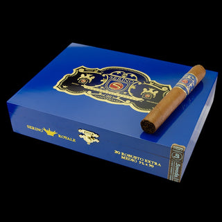 A blue cigar box with gold detailing and a single cigar resting on top, photographed against a solid black background. The box is labeled Serino Royale and Robusto Extra.