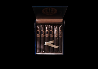 An open premium cigar box displaying six dark cigars with gold-embossed logos, tied with a white ribbon, set against a solid black background.