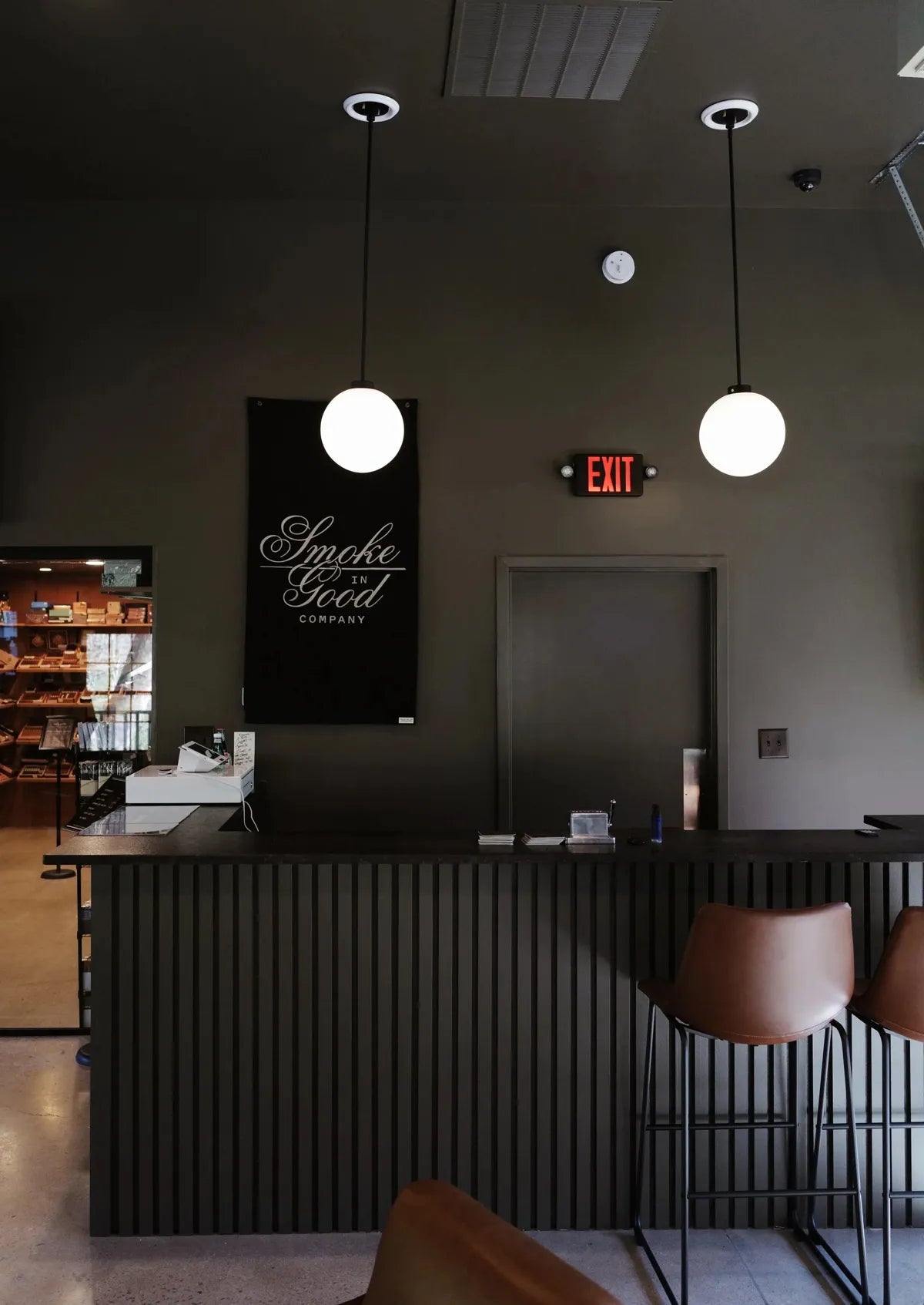 The Creekside members bar with leather stools and a Smoke in Good Company banner